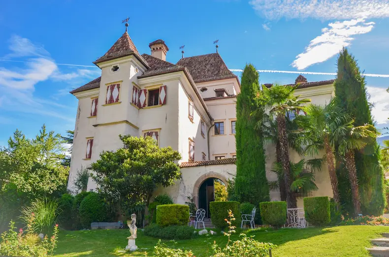 Fraai aangelegde tuinen en hoge, oude bomen zorgen voor een prachtige groene inbedding van 4* Superior kasteelhotel Castel Rundegg. © Castel Rundegg