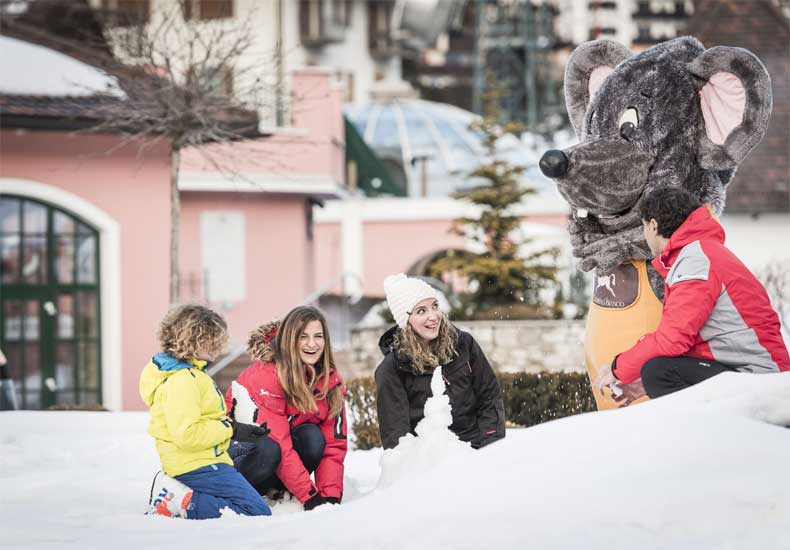 Lekker met z'n allen in de sneeuw spelen bij het Cavallino Bianco Family Grand Spa Hotel. Mascottemuis Lino doet ook mee. © Hannes Niederkofler / Cavallino Bianco Family Spa Grand Hotel