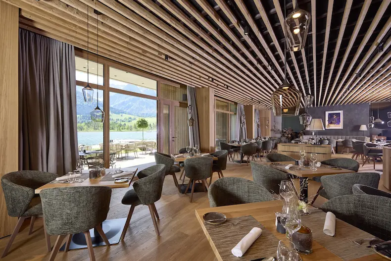 Ook in het sfeervolle restaurant van Das Walchsee Lakeside heb je een prachtig uitzicht op het meer. © Simon Hausberger / Das Walchsee Aktiv Resort