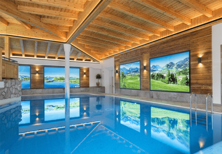 Hotel Alpina heeft een groot binnenbad, maar je kunt ook buiten zwemmen. © Alpina Kössen