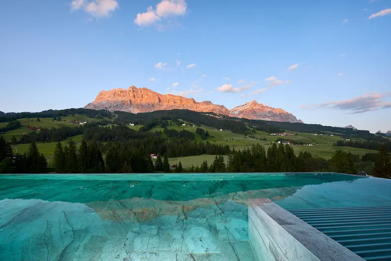Vanuit het panoramazwembad van Hotel Badia Hill heb je een prachtig uitzicht op de Dolomieten. © Visciani Photography / Hotel Badia Hill