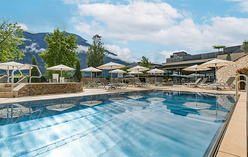 Vanuit het binnenzwembad kun je naar het buitenbad zwemmen. Daarachter ligt de fitness-ruimte. © Hotel Held