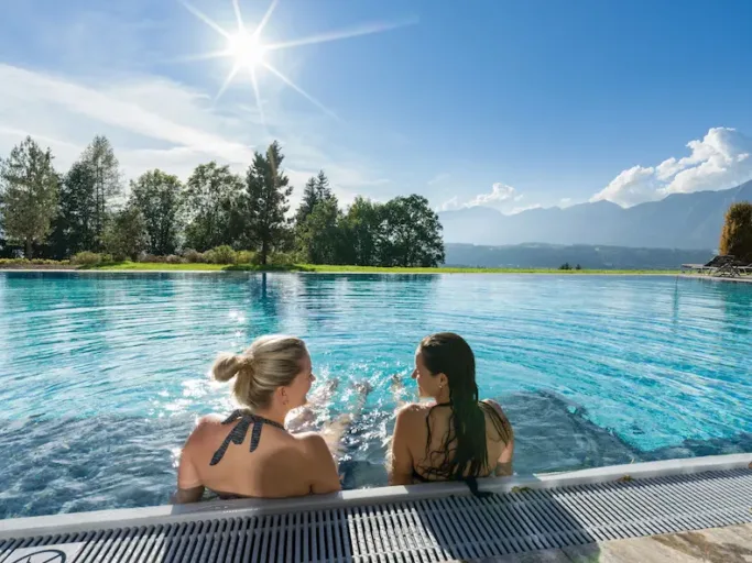 Vanuit het buitenzwembad in Hotel Panorama Royal kun je genieten van de tuin en het prachtige uitzicht over het dal. © Hotel Panorama Royal