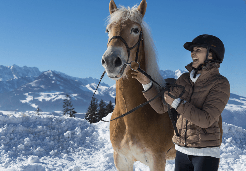 Bij Hotel Peternhof kun je ook paardrijden in de sneeuw met de Chiemgauer Alpen, de Zahmer Kaiser en de Wilder Kaiser op de achtergrond. © Hotel Peternhof