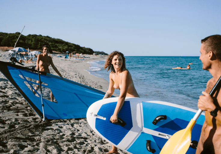 Naakt sporten in de zomer: in je blootje suppen, windsurfen of kanoën kan vanaf het strand van naturistenresort Riva Bella op Corsica. © Riva Bella / Céline Hamelin