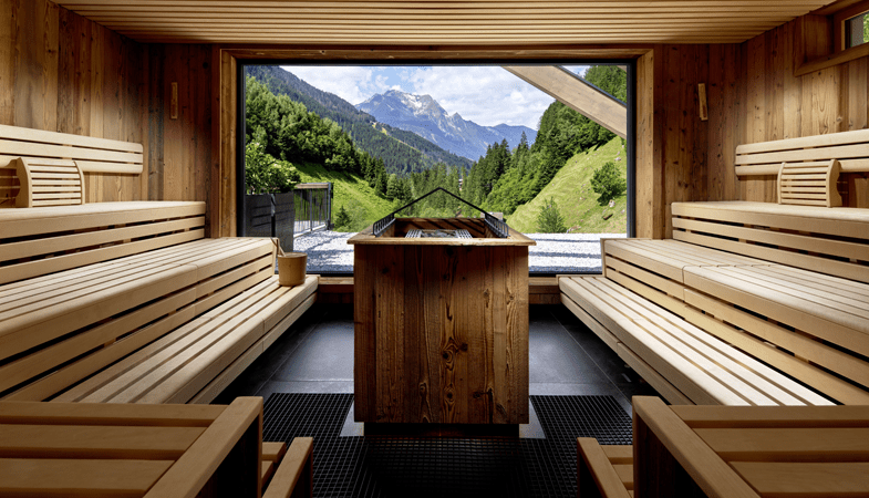 Vanuit de Event-sauna heb je uitzicht op een spectaculair bergdal. Als dat niet het toppunt van ontspannen is, weten wij het ook niet meer. Als © Michael Huber / ZillergrundRock Luxury Mountain Resort