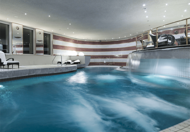 De Aureus Spa van het 5 sterren superior hotel Zürserhof heeft een groot indoor zwembad met waterval © Rainer Hofmann Photodesign (Hotel Zürserhof)
